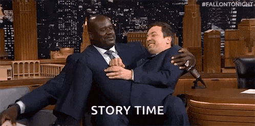 a man in a suit is carrying another man in his arms on a couch .