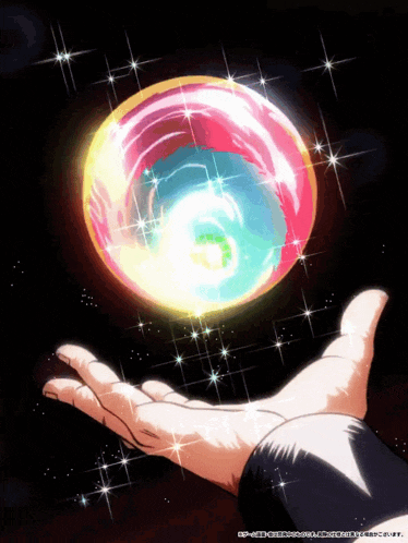 a hand is holding a colorful sphere with chinese writing on it