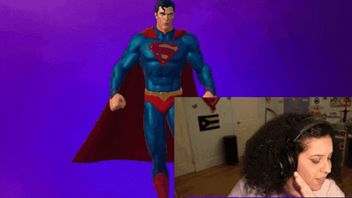 a woman wearing headphones is looking at a superman statue