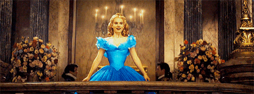 a woman in a blue ball gown is standing on a balcony .