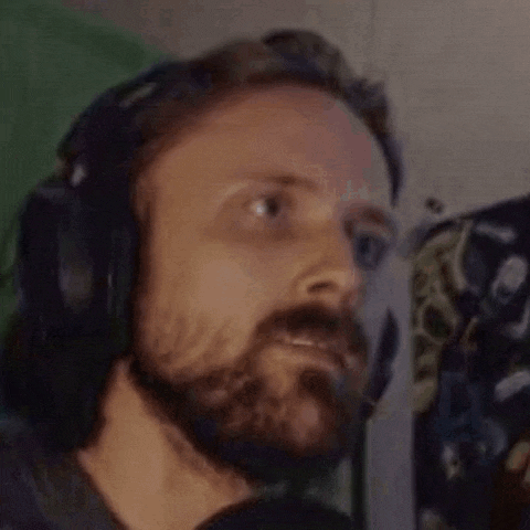 a man with a beard is wearing headphones and a headset .