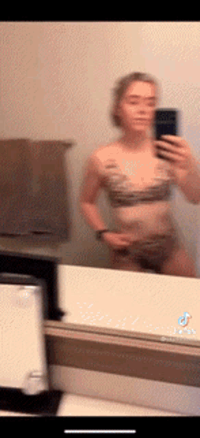 a woman is taking a selfie in front of a mirror