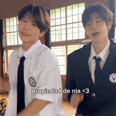 a couple of boys are standing next to each other with the caption propiedad de nia < 3 on the bottom