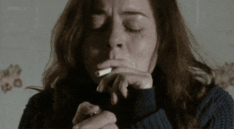 a woman crying while smoking a cigarette with bbc on the bottom left
