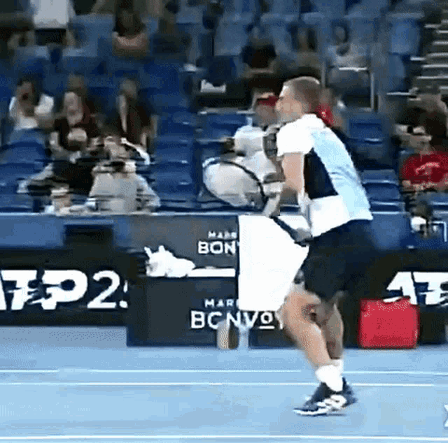 a man is playing tennis on a court with a banner that says tp2