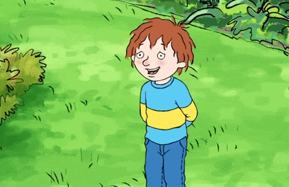 a boy in a blue and yellow striped shirt is pointing at something in the grass