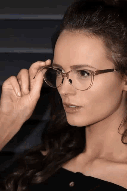 a close up of a woman wearing glasses with a clear frame