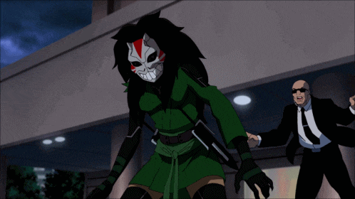 a man in a suit and tie stands next to a cartoon character in a mask