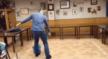 a person is dancing in a room with tables and chairs