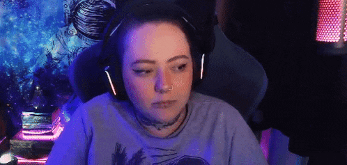 a woman wearing headphones is sitting in a chair and looking at the camera .