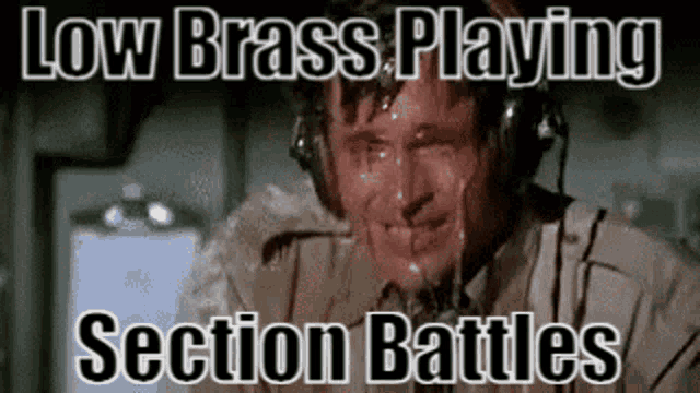 a man wearing headphones is crying while playing a game called low brass playing section battles .