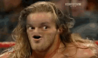 a man with long hair and a beard is making a funny face in a wrestling ring while watching sky sports live