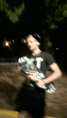 a blurry picture of a person holding a skateboard with a t on it