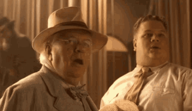 two men are standing next to each other and one has his mouth open