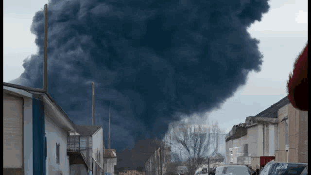 a large cloud of smoke is coming out of a building in the distance