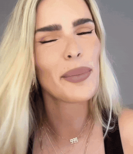 a woman wearing a necklace that says 999 on it