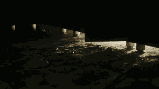 a dark room with a light shining through a door