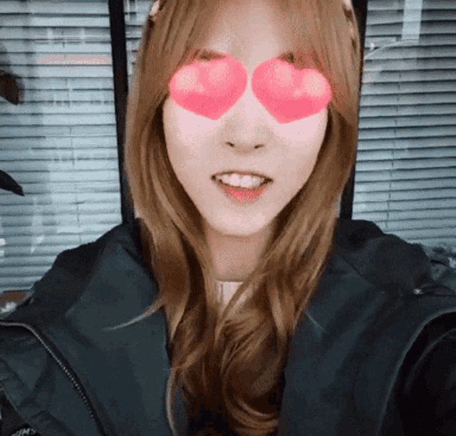 a woman wearing heart shaped glasses looks at the camera