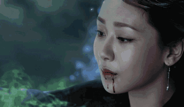 a woman with blood coming out of her mouth is crying