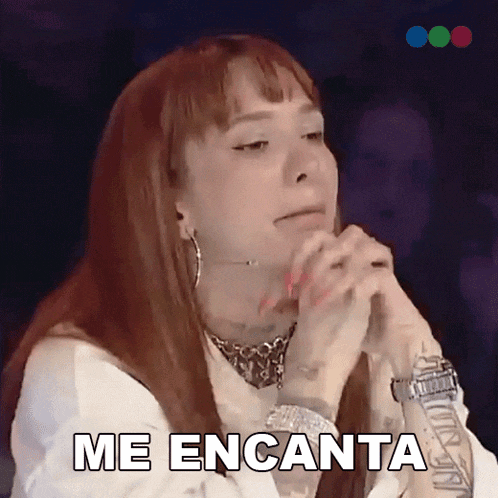 a woman with red hair is saying me encanta with her hands folded
