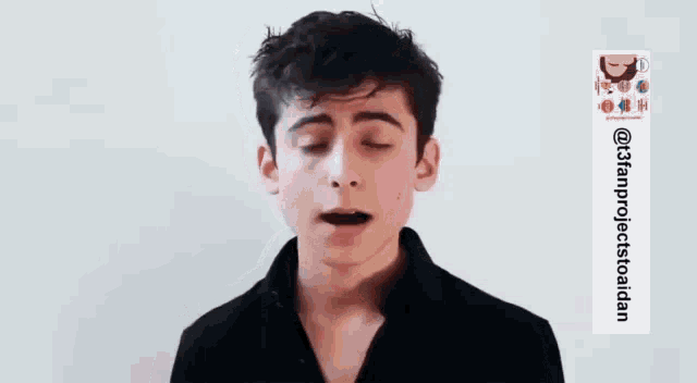 a young man in a black shirt is talking to someone .