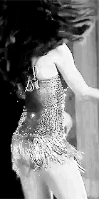 a black and white photo of a woman dancing in a dress .