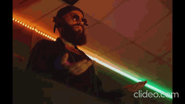 a man with a beard wearing sunglasses and headphones is playing music on a clyde.com website