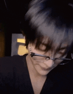 a close up of a person wearing glasses and earring .