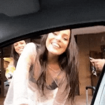 a woman is standing in the back seat of a car .