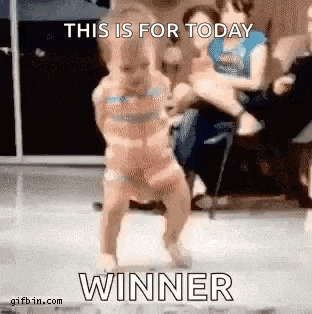 a baby is dancing in front of a crowd with the words `` this is for today winner '' written on it .