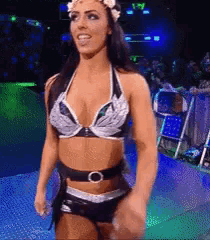 a woman in a bikini is standing on a stage in front of a crowd