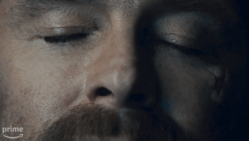 a close up of a man 's face with his eyes closed and the word prime in the corner