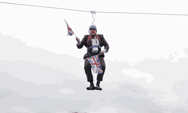 a man in a suit is holding a british flag