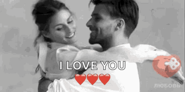 a man is holding a woman in his arms and the words `` i love you '' are visible .