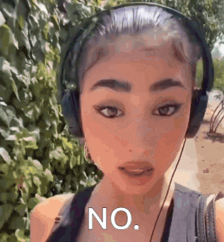 a woman wearing headphones is talking to the camera .