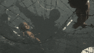 a bird is flying through a barbed wire net in a dark room