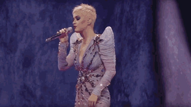 a woman in a dress with wings is dancing on a stage and says this .