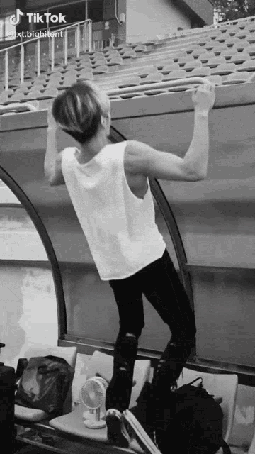 a black and white photo of a man doing a pull up with tiktok written on the bottom