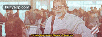 a man with glasses says to help the united states of america in front of a crowd of people