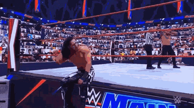 wrestlers in a wrestling ring with a w logo on the corner