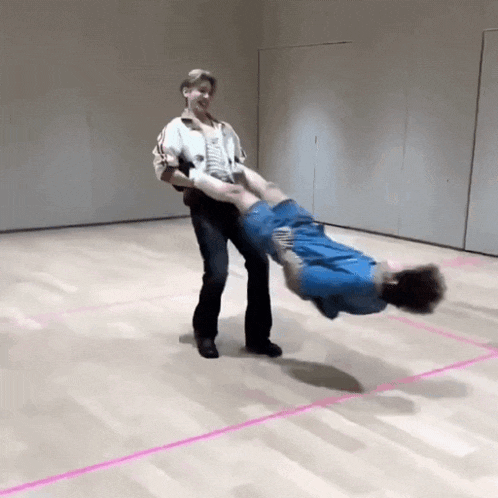 a person is carrying another person upside down on their shoulders .
