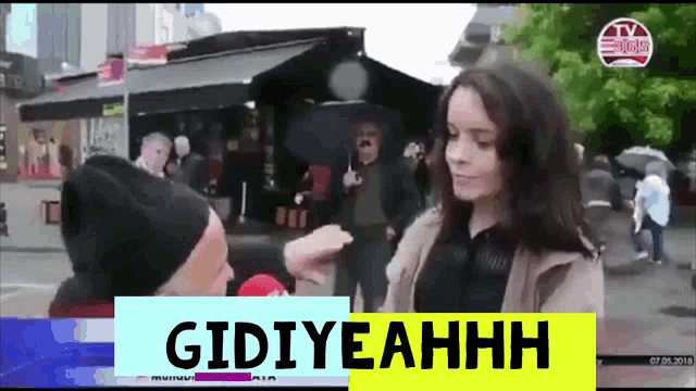 a woman is being interviewed by a man and the words gidiyeahhh are on the bottom