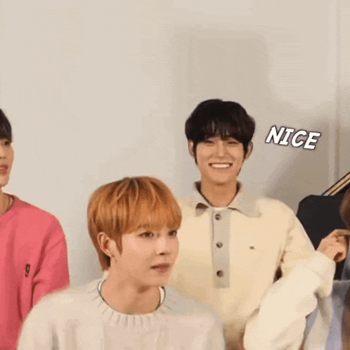 a group of young people are standing next to each other and one of them is smiling and giving a high five .