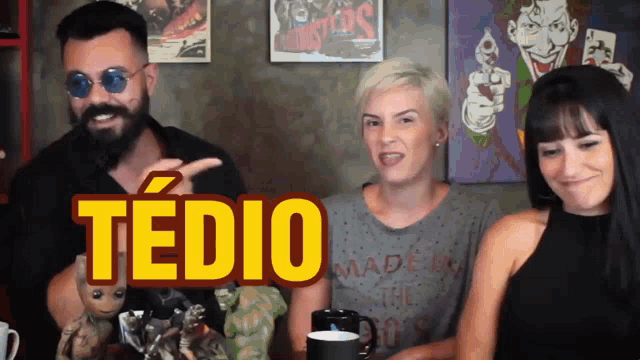 a man and two women are sitting in front of a sign that says " tedio "