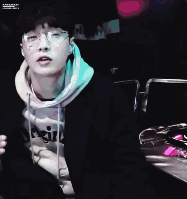 a close up of a person wearing glasses and a hoodie .
