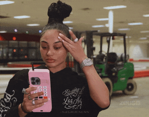 a woman wearing a black shirt that says " rolling up los angeles "