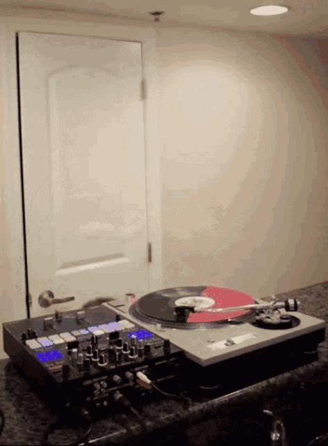 a turntable with a record on it and a mixer next to it