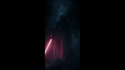a man in a black robe holding a red light saber