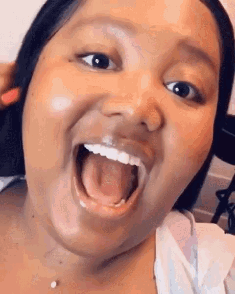 a woman is making a funny face with her mouth wide open