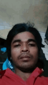 a man with his eyes closed and a red shirt on